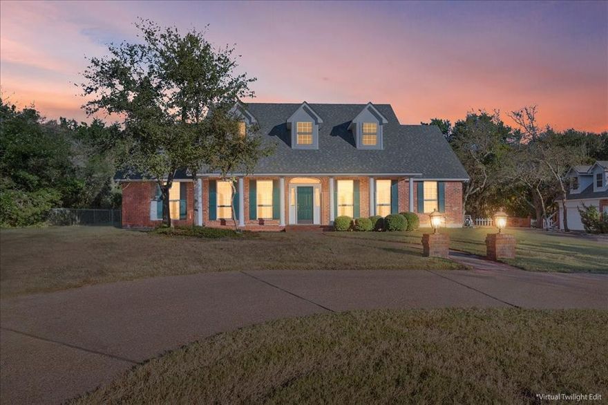 Imagine coming home to this beautiful red brick Southern Colonial Revival, sitting pretty on almost an acre and a half of wooded land so you'll have all the privacy you could ever want. From the moment you pull up, you'll feel that classic charm. The full-length front porch, complete with those graceful columns, the symmetry of the dormer windows upstairs - all add such character. Inside, you'll find a home designed for comfortable living. The main living space is wonderfully open, with the kitchen, living, and dining areas flowing seamlessly together – perfect for entertaining or just keeping an eye on things while you cook. If you need a dedicated workspace, you're in luck! There's a formal office with elegant French doors and built-in cabinetry, making it a quiet and productive retreat. The master suite is a true sanctuary. It's generously sized, and that huge closet? It even has a built-in safe for your peace of mind. The master bathroom is equally impressive, with a separate shower and a relaxing tub, plus two vanities, so everyone has their own space. An additional downstairs bedroom has its own full bath. Upstairs, you'll find a large area perfect for a media or game room, two more spacious bedrooms, and multiple storage areas – because who doesn't need more storage? The bedrooms share a Jack-and-Jill bathroom, a practical setup for family or guests. Now, let's talk about the garages, because this house really delivers there. You've got an oversized two-car attached garage, which is already a plus. But wait, there's more! A detached two-car garage offers even more space, and above it, you'll discover a fantastic bonus room – perfect for a craft room, a home gym, or whatever hobby brings you joy. This house truly has so much to offer, blending classic elegance with modern convenience, all wrapped up in a private, natural setting that’s not too far out of town - just two short miles up Gholson Road from Lake Shore Drive.