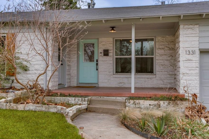 Every so often a home comes along that captures the spirit of North Oak Cliff in a single breath, and this darling Beckley Club adjacent bungalow does exactly that. Tucked among rolling hills where the neighborhood peacocks wander freely, this thoughtfully reimagined 3 bed, 2 bath charmer blends modern updates with the kind of character that makes you feel instantly at ease the moment you step inside. Light pours across the beautifully refinished hardwoods as you move through the bright living spaces, each room grounded by fresh paint, new windows and whimsical design touches. The kitchen is a total scene stealer, with its warm concrete countertops, open shelving, ample storage, and that dreamy corner window framing morning coffee in the prettiest way. Stainless appliances, a spacious walk-in pantry and direct access to the back deck make this space as practical as it is pretty. The primary suite is set apart for ultimate privacy and relaxation, wrapped in custom paneling and shiplap, and anchored by a serene en-suite retreat with double vanities and a walk-in shower. Two additional bedrooms each showcase charming bead board wainscoting and generous natural light, with a cozy full bath between them. Out back, a large wraparound deck invites you to dine under the twinkle lights, host friends, or simply enjoy a peaceful moment overlooking the oversized yard. Perennials and native plantings set the tone out front, while the attached single-car garage adds the everyday convenience you crave. Less than five minutes to the Dallas Zoo, Herndon Park, and the soon-to-open Halperin Park, this special home offers a sense of place that’s hard to find and even harder to leave.