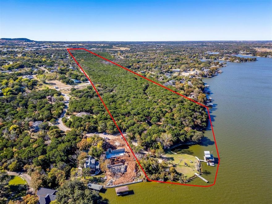 EXCEPTIONALLY RARE main-body lakefront acreage offering with 811 feet of prime shoreline on one of the most desirable stretches of Lake Granbury. Spanning a total of 84.30 acres, this remarkable property presents a truly unique opportunity for investment, development, or a private legacy lakefront ranch retreat, and one of the last large unimproved lakefront properties remaining on Lake Granbury proper. Located just 5–7 minutes from Granbury’s Historic Town Square by vehicle or boat, this property offers a rare mix of both seclusion, tranquility and proximity. From higher elevations on-site, the iconic Granbury Courthouse Clock Tower is visible—an impressive reminder of how close you are to town while enjoying complete privacy in a natural waterfront setting. The main gravel road runs approximately 1.36 miles lengthwise through the property, showcasing 129 feet of gently rolling elevation change—from a minimum of 654 ft MSL to a maximum of 783 ft MSL—offering scenic vistas, natural draws, wet weather creeks and an ideal topographic variance for development or recreational use. The land includes a diverse mix of native hardwoods, including primarily oak, elm, mesquite, and juniper, various limestone outcroppings, as well as a portion of the scenic Contrary Creek, enhancing its ecological richness and aesthetic appeal. Minimal brush clearing has been performed over the years, leaving a myriad of options for a future owner. This is a rare opportunity to own a large contiguous waterfront tract with widespread development potential, significant recreational value, and excellent access from the DFW area—just minutes from the heart of Historic Granbury.