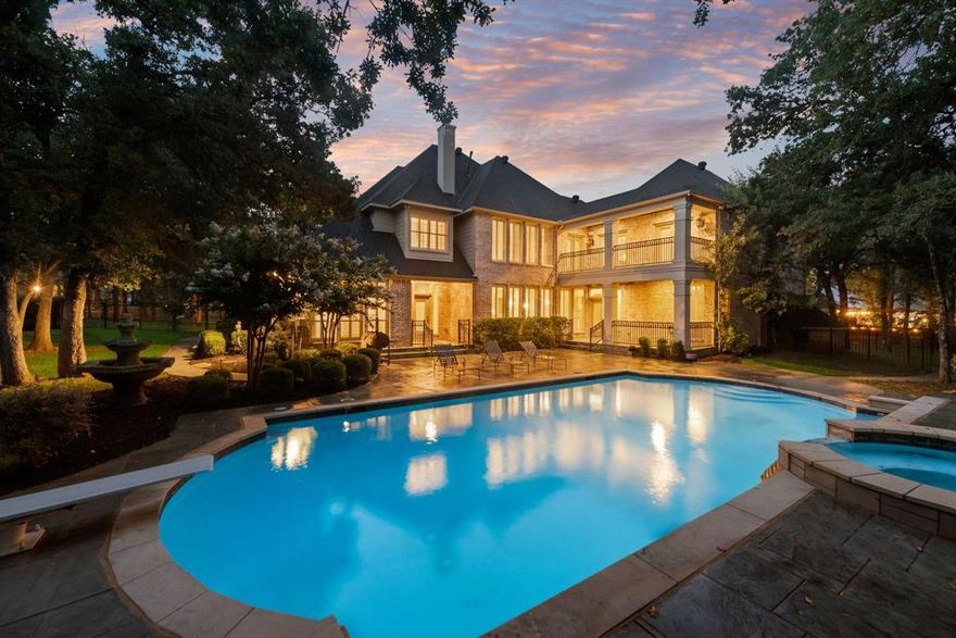 Unparalleled luxury and privacy await on 1.84 beautifully wooded acres in prestigious Argyle ISD. Situated just a short walk from Argyle Middle School, this custom estate exudes timeless elegance, masterful craftsmanship, and modern comfort. Built in 2012, the residence boasts 5 spacious bedrooms, 2 on the main level and 3 upstairs with a unique loft retreat, perfect for family living or multi generational needs. Enter through grand double iron doors into a soaring foyer adorned with custom tile work, rich hardwood floors, and exquisite architectural details. The expansive living area features dramatic ceilings, custom built ins, a striking fireplace, and a seamless flow into the gourmet kitchen and refined dining area, with wet bar designed for both upscale entertaining and everyday luxury. Upstairs, enjoy an oversized game room with a private balcony overlooking the pool, an elegant library, and a fully equipped two-level media room for an unparalleled cinematic experience. Step into your own resort style sanctuary, where a sparkling pool is nestled among mature trees, manicured gardens, and serene views. The outdoor space is crafted for entertaining and relaxation alike, featuring a tranquil fountain, extensive patio space, a charming arbor, and a dedicated dog run, all within a fully private shaded setting. Located in a top rated school district and filled with luxury finishes throughout, this extraordinary home offers a rare blend of elegance, comfort, and exclusivity, a true Argyle masterpiece.