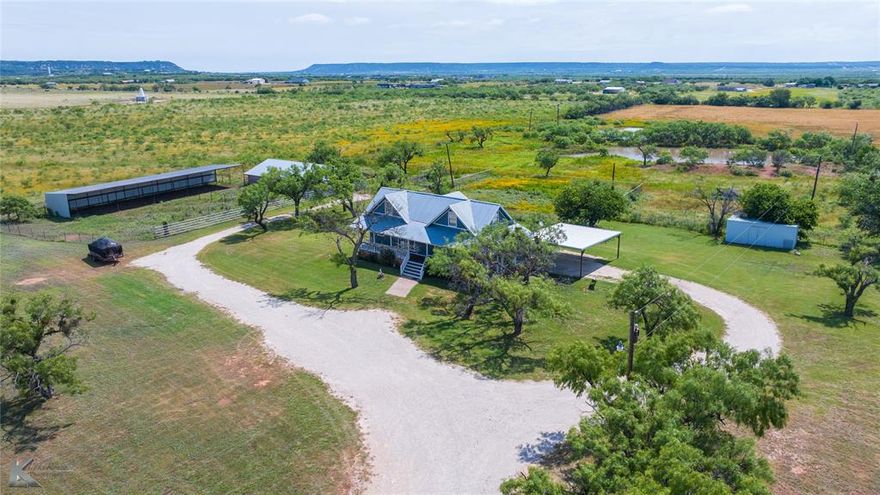 Discover peaceful country living on approximately 30 acres in beautiful Tuscola, Texas, with this charming 3-bedroom, 2.5-bath, 1,760 sq ft two-story ranch-style home. Featuring warm cedar siding, a durable metal roof, and a full-size basement, this home combines timeless design with functionality. Inside, you'll find inviting wood details and a gas stove that anchors the kitchen, adding rustic charm and everyday comfort. Enjoy mornings and evenings on the spacious covered front and back porches, surrounded by mature mesquite trees and endless open views. Ideal for equestrian enthusiasts or anyone seeking a country lifestyle, the property includes a 38x65 horse barn with individual pens, a 100x24 equipment cover, a 552 sq ft heated and cooled shop perfect for hobbies or workspace, a two-car carport, and a one-car garage. Two tanks add to the natural beauty and function of the land, offering water access for livestock or leisure. A winding gravel drive welcomes you home past open fields and native wildflowers, while the surrounding landscape offers room to roam, ride, or relax. This is more than a home, it’s a lifestyle centered on space, freedom, and the beauty of rural Texas living, all just a short drive from Abilene amenities.