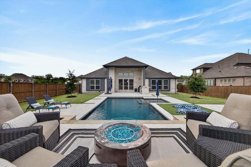 Welcome to this exceptional home on a large corner lot in sought-after Oak Hill Ranch, offering the perfect blend of luxury, function, and resort-style living. This thoughtfully designed home features 4 bedrooms, or the 4th bedroom can serve as an office. Enjoy modern convenience with a keyless front door and Home Pro Z-Wave smart light switches throughout. The open-concept kitchen is a standout, featuring quartz countertops, a large island, high-end finishes, a 5-burner gas cooktop, double ovens, and a new Bosch dishwasher—perfect for everyday living and entertaining. The spacious living area boasts soaring ceilings and a gas fireplace, creating a warm and inviting atmosphere. A large attic offers excellent potential to expand into additional living space, media room, or guest suite. The home includes two separate garages accommodating 3 cars, complete with epoxy flooring and an EV charger. Energy-efficient upgrades include Tesla solar panels and a Tesla Powerwall. Step outside to your private backyard oasis. The architecturally designed 8-ft deep pebble sheen pool features beautiful waterfall elements and a lounge deck. The outdoor kitchen includes a built-in grill, refrigerator, and bar-top seating. The backyard also offers a stylish mix of turf and hardscape with multiple entertaining areas, a standalone hot tub, and a private enclosed dog run. A rare opportunity to own a home that truly has it all in a prime DFW location!