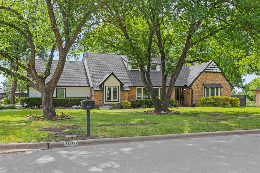 Tucked on over half as acre, this 5-BR, 3.5-bath home blends timeless charm and thoughtful updates with a unique floorplan featuring 2 primary suites.  Mature trees and expansive lawns welcome you, while special touches, like cozy window seats, add warmth and character throughout. Both primary are located on the first floor.  The front suite includes an adjoining bedroom currently used as a nursery, but perfect as a private sitting room, office, craft, or fitness space. A second, generously sized primary suite is tucked at the rear with its own ensuite bath. Open living, dining and breakfast areas are designed for everyday comfort and easy entertaining. The living room showcases built-in shelving and a beautiful stone fireplace, while the spacious dining room is lined with windows overlooking the lush front yard. The updated kitchen shines with abundant white cabinetry, quartz counters, gas cooktop, farmhouse sink, and pantry, seamlessly connecting to the dining and breakfast areas. A stylish half bath completes the main level. Upstairs, two additional bedrooms include an oversized retreat with THREE walk-in closets and ensuite access to a full bath that also opens to the hallway. A walk-in attic room provides excellent storage. Step outside to your own backyard oasis with a private patio, sparkling pool, large grassy yard, play structure, and storage shed.  There’s plenty of space here to relax or entertain!  Ideally located near Lake Ray Hubbard, and less than 5 minutes elementary and high schools, this home is also close to parks, shopping and dining.