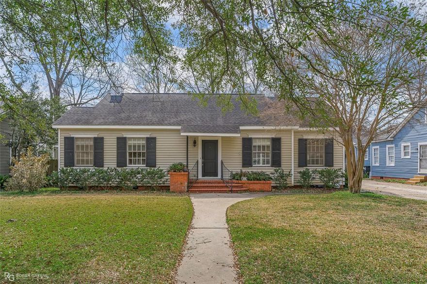 South Highland charm with that cottage feel we all love. From the moment you pull up, the curb appeal speaks for itself. Mature trees, classic shutters, and a welcoming front entry that just feels like home.
Step inside and you’ll notice all the natural light pouring through those large windows and hardwood floors. This home offers two living spaces. The living area is highlighted by a dramatic coral-inspired designer chandelier. A custom statement fixture that adds artistic character and warmth to the space. The formal dining room is perfect for gathering, Sunday dinners, or just everyday living. The kitchen has a great layout with plenty of cabinetry and counter space, plus a new dishwasher already in place. Three bedrooms and two full baths offer comfortable space, including a spacious primary suite with a great bathroom featuring a separate stall shower, walk in closet. Outside, you’ll love the wood deck overlooking the large fenced backyard. Room for kids, fur babies, or simply enjoying your own space. There’s also a shop garage area tucked in the back, giving you extra storage or workspace options. And let’s not forget a full-home generator for added peace of mind. If you love southern old homes and appreciate character in this one is worth seeing in person. Come see it for yourself.