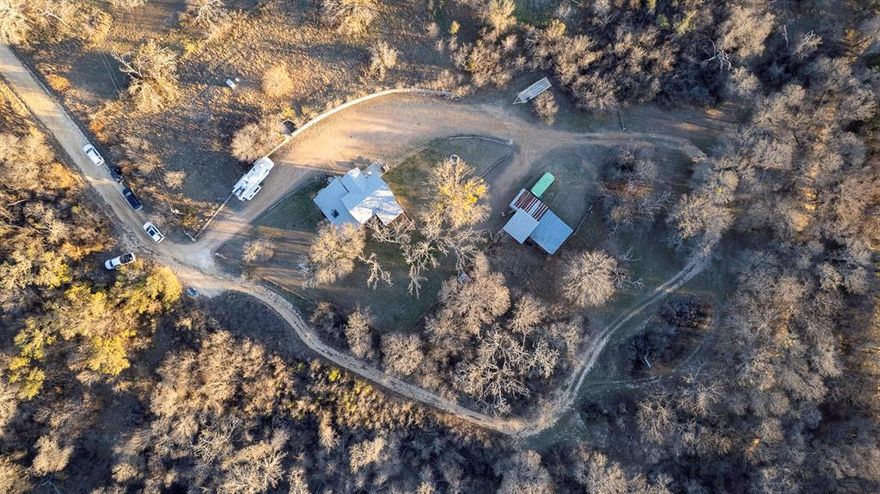 Situated on nearly 3 beautiful acres in a secluded setting near Proctor Lake, this versatile property offers 2 or could be 3 bedrooms and 2 bathrooms. The bonus room could easily serve as a third bedroom, home office, hobby space, or additional storage. The primary suite features an en-suite bath with a shower and separate  relaxing soaker tub, separate closets, and private access to a deck—perfect for enjoying quiet mornings and evenings. The living room opens to a screened-in porch, extending your living space outdoors and creating a seamless connection to the surrounding natural beauty. Mature trees provide shade and privacy, while the expansive acreage offers endless possibilities for a shop, garden, outdoor entertaining, or simply enjoying the freedom and tranquility of country living near the lake.