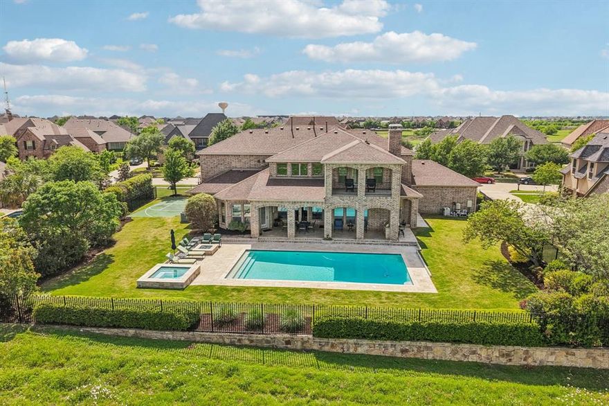 Tucked away on a quiet cul de sac in a gated Frisco community, this custom built, owner designed nearly 6,000 sq ft of thoughtfully curated living space a backyard situated on almost half an acre, the outdoor space feels like a private retreat w- lush wildflowers, a fire pit, expansive entertaining areas, peaceful views of both the greenbelt & Lake Lewisville. 
The moment you arrive, double wrought iron doors & a grand split staircase create a striking first impression. Rich wood flooring flow throughout the main living areas, staircase, & 2nd floor, complemented by new carpet in the bedrooms. Spacious kitchen is designed for gathering, offering generous workspace-seamless flow into the main living areas.
A private office & 2 primary bedrooms on the main level. Front suite features a full ensuite bath & walk-in closet, while the main primary suite offers dual walk in closets. Home is designed for both everyday living & entertaining, abundant storage throughout, including a large walk in storage closet upstairs.
Upstairs 3 additional bedrooms, 2 with ensuite baths, a game room, fully equipped media room w- projector & equipment included. A private balcony off the game room provides elevated views of the greenbelt & lake.
Backyard oasis features oversized heated pool & spa that were retiled with new coping in 2025; along with a covered patio, multiple seating areas, outdoor fire features, & a basketball court. Home was intentionally positioned forward on the lot to maximize this exceptional outdoor space, creating a setting rarely found in Frisco.
Additional highlights include a 3 car garage w- an oversized 2 car bay ideal for trucks, storage, large utility room with sink & coffee bar, gas fireplaces in both living room & outdoor living area, 4 Trane HVAC units.
Located in FISD & zoned for Reedy HS. Enjoy access to community amenities, including a pool, fitness center, playground, community center, a peaceful neighborhood known for wide streets & private feel.