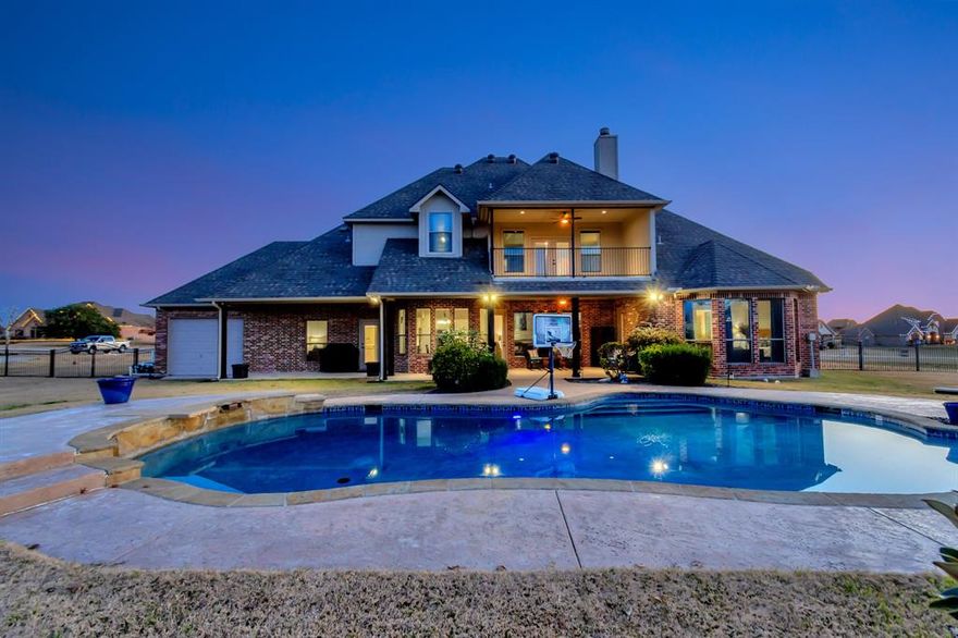This exquisite home boasts 5 bedrooms and 4.5 baths situated on over 1 acre of scenic beauty, featuring a stunning pool that enhances the outdoor living experience. The interior showcases an inviting open-concept kitchen and a main-level primary suite with a luxurious en-suite complete with a jetted tub, walk-in shower, dual vanities, and a generously sized walk-in closet. A second guest bedroom on the main level enjoys a private bathroom. Upstairs, a spacious gameroom with a wet bar awaits, alongside three additional well-appointed bedrooms. Also featured upstairs is a large bonus room which could easily be used as a 4th bedroom, plus two attic spaces providing tons of storage.  The property benefits from a private well, eliminating water bills, and is located outside city limits in the charming Vista Ranch community, within the highly regarded Northwest Independent School District. Enjoy the tranquility and elegance of this exceptional residence.