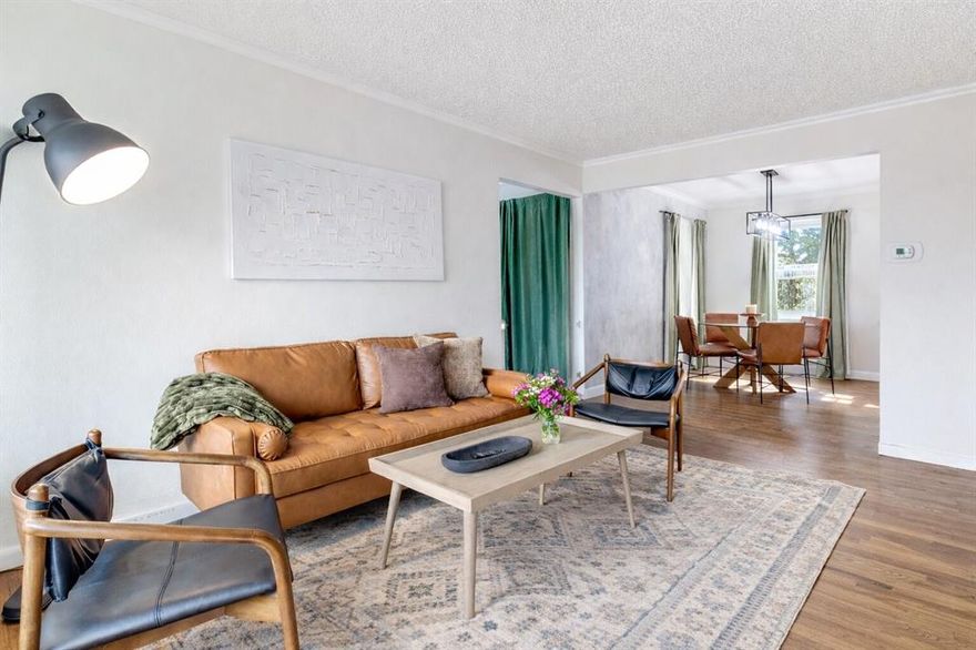 Welcome to this bright and inviting home in the vibrant Forest Oaks neighborhood of East Dallas, where natural light, warm hardwood floors, and an open layout create a space that feels both comfortable and full of possibility. The main living, dining, and kitchen areas flow together easily, making everyday living and entertaining feel effortless. Three bedrooms and a full bath are tucked along the south side of the home, offering a sense of privacy from the main living spaces. Just beyond the living room, a spacious flex room adds incredible versatility with plumbing access already in place. This flexible area can easily serve as a second living space, home office, playroom, or guest retreat, with the potential to create a large split primary suite. A rendering showing the space reimagined with an added half bath is available at the transaction desk. Step outside to a large backyard that offers a true blank canvas for outdoor living, gardening, or future landscaping projects. A pergola creates a natural spot for relaxing or entertaining, and the yard is supported by a sprinkler system. A rear carport provides covered parking. Enjoy an unbeatable East Dallas lifestyle just a short walk from Saint Francis Park and only minutes from White Rock Lake, the Dallas Arboretum, Casa Linda Shopping Center, popular dining spots like Smoky Rose, and miles of nearby trail systems. Zoned to Alex Sanger Preparatory.