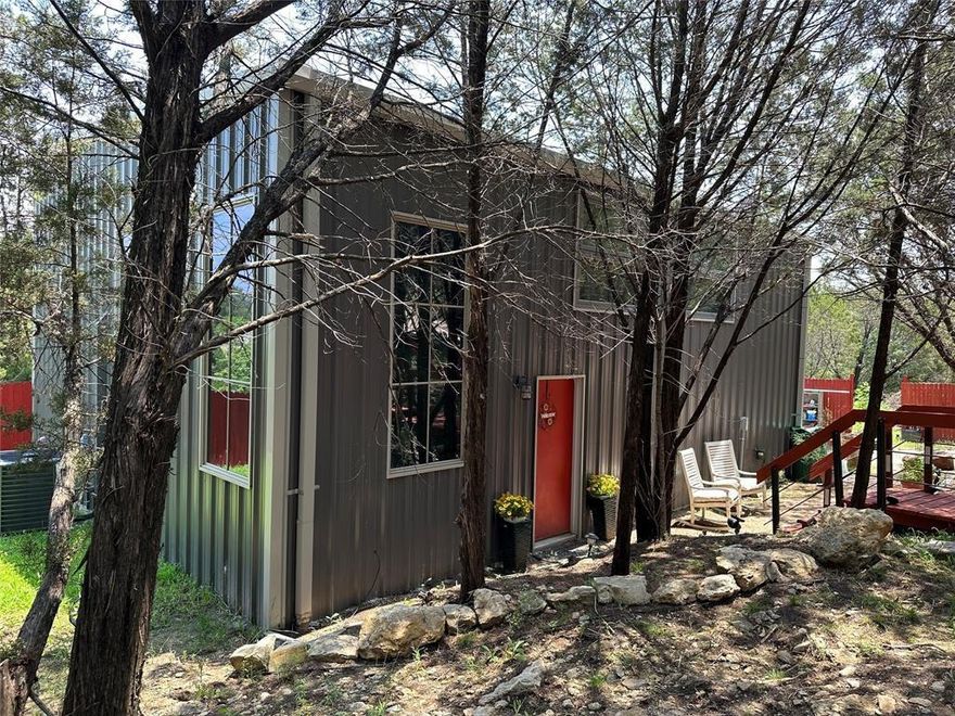 Escape to this secluded hillside retreat surrounded by mature trees overlooking seasonal creek. Sit on the back deck and enjoy the wildlife. This modern industrial style home has an open concept with an oversized concrete island and vaulted ceilings. The glass doors open up to the gorgeous deck which goes down to the creek. First floor has living area, kitchen, dining room , laundry, storage area, and an office or flex area. Second floor has 2 bedrooms with adjoining full baths and an additional flex room. This home also boast a covered carport. The Lake is only blocks away and has access to a community boat dock. The back deck offers a lovely view and room to host family and friends for BBQs. Inside you will find industrial modern features of a fully open concept including a living area, flex area, dining room, laundry, full bath and pantry. The kitchen boast all new appliances that will convey. Second floor has 2 bedrooms with adjoining full baths and an additional flex room!