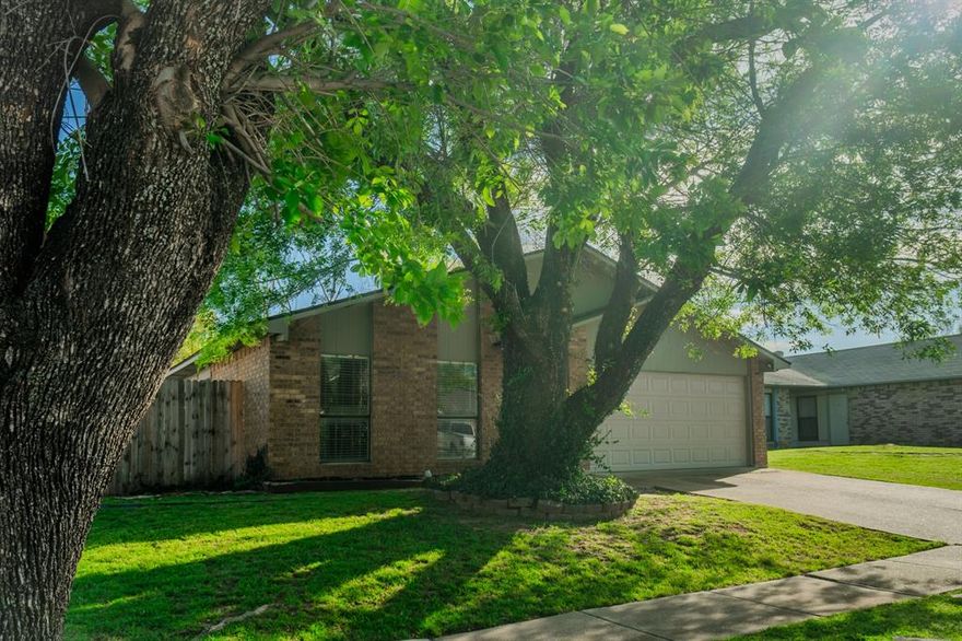 Tucked away just moments from Lake Arlington, this home is not only in a convenient location, but ready to go for its new owner. The spacious living area is anchored by a cozy brick fireplace with a raised hearth and mantle, making it an ideal spot to gather or unwind. Large windows allow natural light to pour in, enhancing the open feel of the main living space. The kitchen offers great functionality with ample cabinetry, generous counter space, and a convenient pass-through opening to the living area, perfect for entertaining or staying connected while cooking. One of the standout features of this home is the dedicated built-in workspace at the end of the hall, complete with shelving, ideal for a home office, study nook, or hobby area. This well taken care of home has new carpet in all the bedrooms, fresh paint throughout, a new perimeter privacy wood fence, and a custom firepit area to enjoy in the evenings. Out the French doors from the kitchen, the turfed side patio is great for grilling out or letting the kids play. This yard is unexpectedly bigger than you'd imagine for a home in town and comes with an 8x8 storage shed. The two-car garage has built in cabinets, workspace, and a new garage door with opener. Roof was recently replaced in November of 2025.