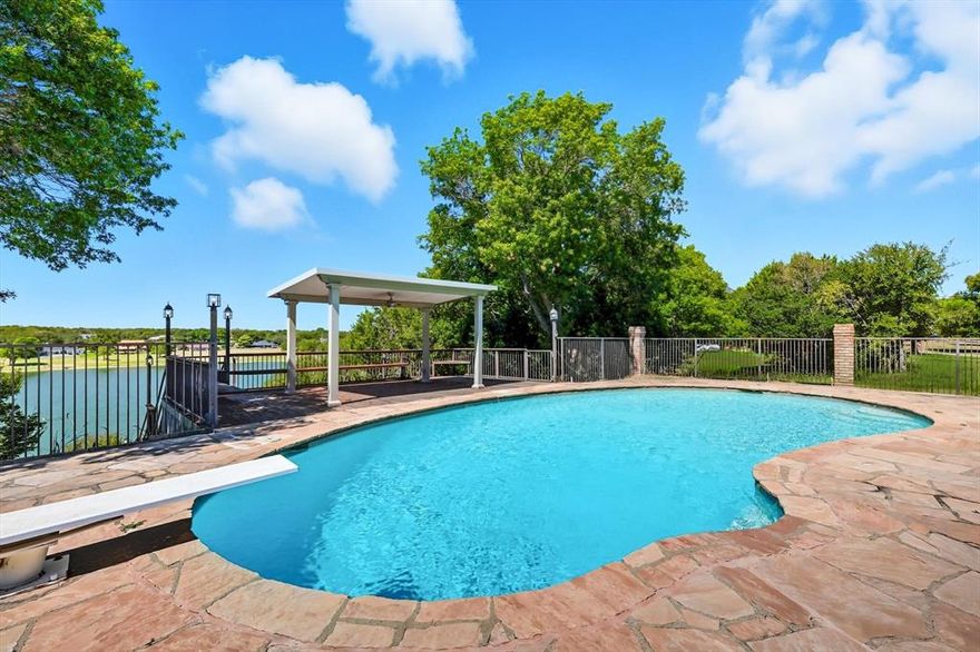 Welcome to 143 Lakeview Drive, a stunning custom lakefront estate in the sought-after Deer Creek community of Aledo. Set on 3.029 acres with direct lake frontage, this 4,073 sq. ft. home offers 4 bedrooms and 4.5 baths designed for both everyday comfort and exceptional entertaining. Soaring ceilings and multiple living areas create an open, inviting atmosphere. The gourmet kitchen features granite countertops, an eat-in bar, upgraded appliances, and flows seamlessly into the spacious living room with a gas fireplace. The primary suite is a serene retreat with breathtaking lake views, dual vanities, and a walk-in closet. Above the garage, a private game room with a full bath and storage adds flexible living space. Upstairs, a loft and three additional bedrooms—each with ensuite baths—provide ample room for family and guests. A dedicated office, formal dining room, and breakfast nook enhance functionality. Outdoor living shines with a covered patio, pool, and unforgettable Texas sunsets. The property is complete with a 3-car side-entry garage plus an additional detached single-car garage for tools and storage. This rare lakefront offering blends acreage, privacy, and convenience—just minutes from downtown Aledo and an easy commute to Fort Worth.