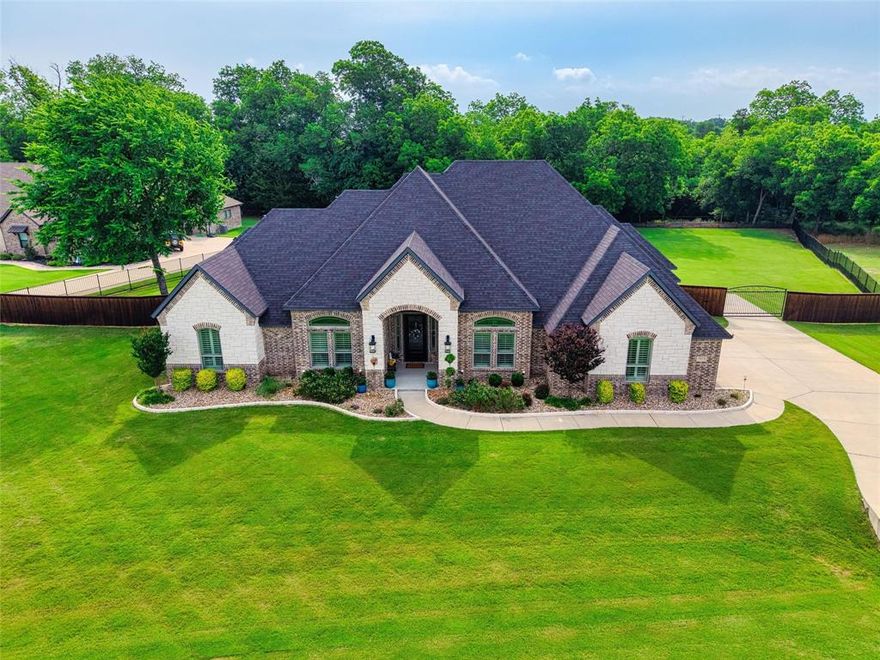 Welcome to this stunning Olson Custom Home—where luxury living meets exceptional value. Situated on a generous 1.57-acre lot in the highly sought-after Longbranch Estates, offering the perfect blend of peaceful country living and everyday convenience. Located within top-rated Midlothian ISD and just minutes from all three schools, the new Tom Thumb, and major highways (287, 67, and I-35), commuting to DFW is effortless.
Thoughtfully designed, this home features 4 bedrooms, 3.5 bathrooms, a private office or flex space, and a spacious second living or game room. The inviting main living area is anchored by a stone fireplace and opens to the chef’s kitchen—complete with a massive walk-in pantry. A light-filled dining area overlooks the expansive backyard and leads to a beautiful covered patio with slate flooring.
High-end finishes include hand-scraped wood floors, custom plantation shutters, stunning trim, elegant tilework, and abundant custom cabinetry throughout. The private primary suite is a true retreat, featuring a spa-inspired bath with a walk-through double shower, whirlpool tub, and a large custom closet. A secondary bedroom offers its own ensuite bath, while two additional bedrooms share a spacious, beautifully appointed full bath.
The oversized game room includes a granite dry bar, glass-front cabinetry, and a convenient half bath with direct patio access—perfect for entertaining.
Enjoy cool, shaded evenings on the east-facing back patio overlooking a fully fenced, oversized backyard that backs to a peaceful, tree-lined, spring-fed creek—providing serene views and added privacy. 
Additional features include two tankless water heaters, water softener, spray foam insulation (incl the garage), and energy-efficient HVAC enhancements. Offering flexible living, generous storage, and the quality craftsmanship Olson Custom Homes are known for—often found in million-dollar properties.
A rare opportunity to enjoy space to enjoy, luxury, and location all in one.