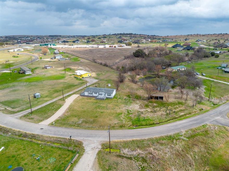 One of Palm Harbor Home's most popular floor plans back in its day!  Ready for immediate move in.  Inside there's an island kitchen with built in desk-workspace, appliances include an electric range and dish washer.  Master suite features an ensuite bath with garden tub and separate shower, plus a big walk-in closet.  Large lot with a few trees and access to a pond.  Big decks at the entrances.  Home is in its original install location, so FHA, Conventional financing are available as well as VA and zero-down USDA.  Great location between Weatherford and Springtown!