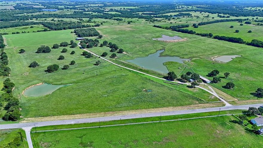 116 Acres of Texas Beauty and Opportunity! This incredible 116 acre property with scattered oak trees and Fm 1749 frontage offers the perfect blend of natural charm and agricultural functionality. Along with a move-in ready home with panoramic views, this is a haven for ranchers and dreamers. This well-designed property boasts expansive acreage covered in lush coastal grass, ideal for grazing and hay production. The land is thoughtfully cross-fenced and features a fully operational set of corals, streamlining livestock management and rotational grazing. With 2 water wells, including one conveniently located near the corrals and 4 large ponds, your cattle will always have access to a reliable water source. Property also includes a large, impressive, insulated shop with roll-up doors, separate office space and outdoor coverage perfect for storage or workspace. Additionally, there are 3 electric meters, a barn, and a large covered parking area for tractors and equipment. This exceptional find also has a sprawling 2,264 sq ft, 3 bed 2.5 bath home positioned to take advantage of the gorgeous views. The home has an open floor plan and split-bedroom layout offering ample space and opportunities for the entire family. The kitchen with granite counter tops and double oven is open to the main living area and has a pass-through opening into the large flex space with an additional fireplace. Whether you are looking to expand your herd with this ready-to-go operation or settle into peaceful country living with room to grow, a property with acreage of this Quality is a rare find.