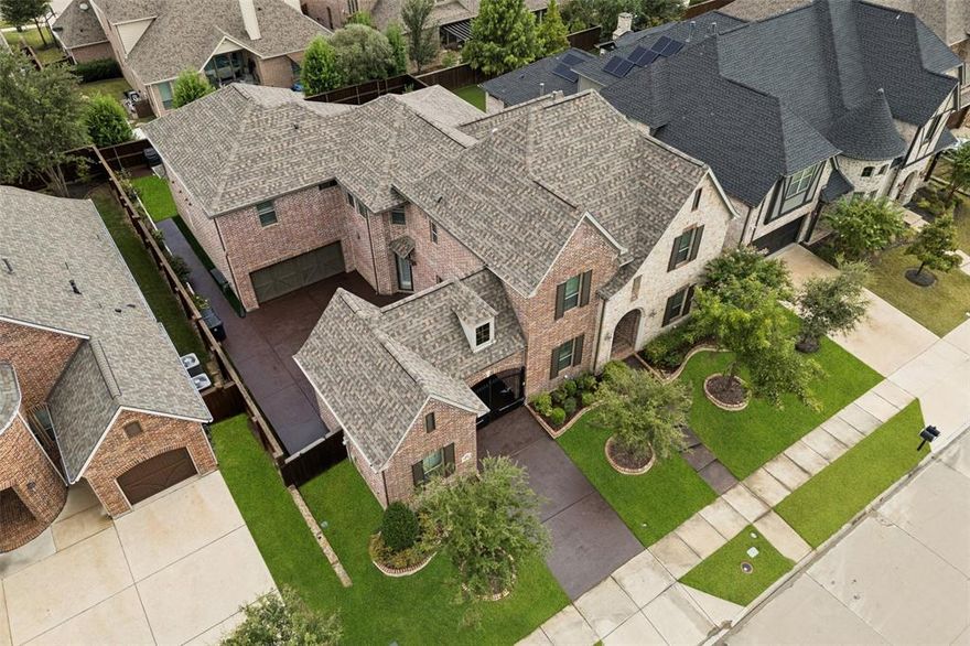 Five bedrooms, five bathrooms, and approximately 4,800 square feet define this north-facing custom Shaddock home in Frisco, Texas, zoned to Frisco ISD and located in Denton County. Ideally positioned near the Dallas North Tollway and Sam Rayburn Tollway, this residence offers flexible living space and meaningful system updates within one of Frisco’s established communities.  The thoughtfully designed floor plan includes a primary suite and secondary bedroom on the main level, providing versatility for guests or extended stays. Upstairs features three additional bedrooms — two with private ensuites — along with a spacious game room, dedicated media room, and card nook. For buyers seeking five bedrooms with two downstairs and defined entertainment areas, this layout delivers both comfort and function.  Recent improvements include a new Class C roof installed in November 2024 with lightning rod protection, refinished hand-scraped hardwood flooring, and new carpet upstairs. Plantation shutters, solar tubes, and fresh interior paint enhance natural light throughout. The kitchen is equipped with premium appliances, an expansive island with seating, and generous cabinetry. A water softener and reverse osmosis system add everyday convenience. Exterior highlights include an electric metal privacy gate, Porte cochere, stained concrete driveway, and a three-car garage with epoxy flooring. A 600-square-foot screened patio extends the living space outdoors, complemented by artificial turf and custom stone landscaping designed for low-maintenance appeal.  Located near The Star, Stonebriar Centre, PGA Frisco, and convenient to Legacy West, the home offers access to premier retail, dining, and major employment corridors.