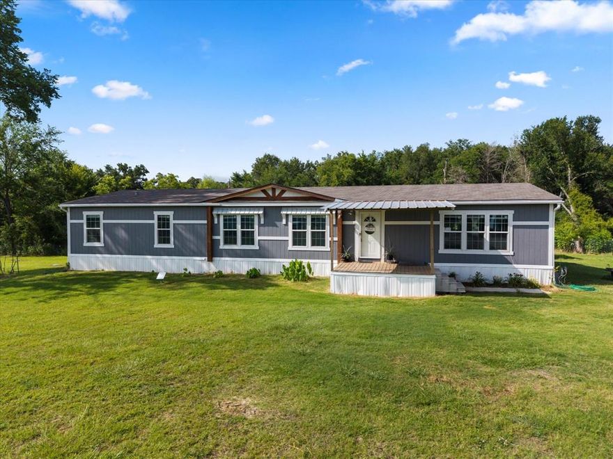 Welcome to country living with comfort and style! This beautifully maintained 4-bedroom, 2-bathroom double wide sits on 2.5 fully fenced and gated acres, offering privacy, space, and functionality. Inside, you’ll find a bright and open floor plan featuring a spacious living room as well as a well-appointed kitchen with ample countertop and cabinet space, a built-in microwave, electric range, farmhouse sink, and a generous pantry—plus a separate butler’s pantry for even more storage and prep space. The spacious primary bedroom is a true retreat, complete with a huge en suite bath that includes a garden tub, large walk-in shower, two vanities, and a dedicated dressing table. There are 3 other bedrooms generously sized and the hall bath features dual sinks.  The utility room has space for a full size washer & dryer, plus room for a freezer! Outdoors you have a generous outline of trees, property is fenced and gated, and theres a seasonal creek on the property as well.  Seller is leaving a storage building and there's another storage structure behind the house, and the seller will also leave the chicken coop! Whether you’re enjoying quiet evenings or entertaining guests, this home offers room to spread out both inside and out. Don’t miss the chance to make this peaceful slice of country life your own!