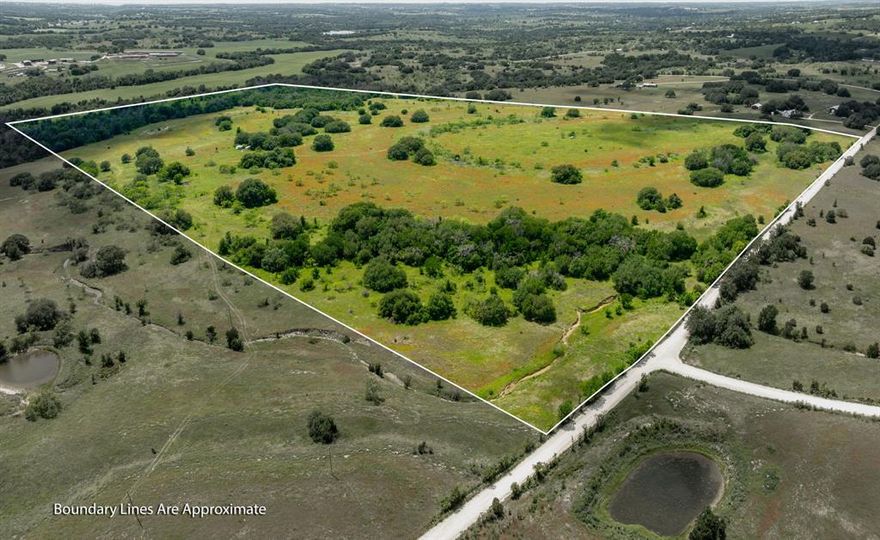 Welcome to this expansive 117-acre property, a true Texas landscape offering endless possibilities for those seeking space, privacy, and a connection to the land. With an existing agricultural exemption in place and no known restrictions, this property is ready to support a wide range of uses that suit your personal lifestyle. Convenient and ready for your plans, electricity is already on-site, making it easy to get started with any plans you may have in mind. The land features varied terrain with beautiful elevation changes, creating scenic views, natural drainage, and a sense of depth and character across the acreage. At the back of the property, a seasonal creek adds both charm and a tranquil feature to explore and enjoy. You’ll love the presence of the scattered live oak trees, which provide natural shade and beauty, as well as the ample open pasture space, perfect for grazing livestock, horseback riding, or simply enjoying the wide-open outdoors. The entire perimeter is fully fenced with barbed wire, making it ready for cattle or horses from the start. There are no known pipelines on the property, allowing for more freedom in how you utilize the land. You'll enjoy the luxury of not being too far from town, while also having ultimate privacy and peace in the country. Whether your dream is to establish a homestead, run a working ranch, or create a peaceful weekend retreat, this property has the space and features to support it. Bring your livestock, your outdoor hobbies, and your vision, and make this special place your own personal sanctuary in the countryside.