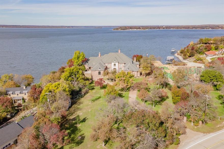 Welcome to this exquisite property on Eagle Mountain Lake, a sanctuary of luxury and comfort. Boasting 5 bedrooms, 6 full baths, and 2 half baths, this home offers ample space and opulence. With 4 living areas and 2 dining spaces, it is designed for both relaxation and entertainment. The grand entrance reveals a breathtaking lake view through the family room, with a formal dining room to the right and the primary suite to the left. The suite is a haven, featuring a sitting area with a see-through fireplace, dual bathrooms, expansive walk-in closets, heated floors, a wet bar with wine fridge, 2 walk in closets, and more. There is also a fitness room located off the primary suite as well as laundry room and an additional bathroom with a steam shower and safe room. The gourmet kitchen, equipped with top-tier Viking appliances, is an entertainer's dream with Viking double ovens, full size wine fridge, two dishwashers, Viking 6 burner gas cooktop, trough sink in the island, sink has hands free foot pedal, walk in pantry, lighted cabinets, and built in fridge. An in-law suite adds versatility, complete with a bedroom, full bath, and a secondary kitchen. Upstairs, three bedrooms, a game room, media room, and office with balconies offer stunning lake views. The backyard is a paradise with an infinity pool, outdoor kitchen, fire pit, gas fireplace, outdoor shower and a boat dock trolley. There are also outdoor shades for the patio.  Sides drop to shield from heat and cold to allow for more outside time. This smart home includes a Control 4 system, water filtration, foam insulation, multiple wet bars, and ample storage. Dog run just outside the breakfast nook. Discover endless features and modern comforts in this stunning lakeside retreat. There are also 3 - 2 car garages.  One is below the 2 car garage on the left hand side with an entrance in the garage. Be sure to check out the feature sheet with all this luxury home has to offer.  This gorgeous home is a must see!