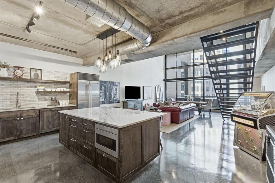 Ultra-Luxurious Industrial 2 Story Soft Loft with Unparalleled Uptown Location. Fall in love with urban luxury, and start having the good life in one of Uptown Dallas’s most coveted buildings! Poignantly situated in an enviable area, this residence benefits from an exceptional location with many conveniences just moments away. Overflowing with natural light, the supremely stylish interior captures the perfect blend of sophisticated comfort and intelligent utility. Explore the open floorplan to discover floor-to ceiling windows, gorgeous contemporary light fixtures, durable concrete floors, and intoxicating cityscape views. Gourmets are sure to discover the chef’s kitchen of their dreams. Boasting a modern French-country vibe, the Michelin-worthy kitchen dazzles with a marble-topped breakfast bar island, Sub-Zero wine refrigerator, 8 burner Wolf gas stove, Sub-Zero refrigerator, open shelving, custom cabinetry, and Quartzite counters.  Eager for entertaining, the expansive living room serves as a formidable, yet welcoming gathering space. Soaring ceilings and cityscape views beckon guests to the covered balcony. Easily serve a bright chardonnay to lift the mood to new heights, while you and your guests admire the sparkling lights of the “Big-D.” After a successful day of hosting, retire to the impressive primary bedroom, which has a fabulous walk-in closet and stunning en suite. Soak in the showstopping bathtub, rinse away the cares of the day in the step-in shower, or simply enjoy the convenience of a dual sink vanity. Other considerations include two assigned parking spaces in secure garage, in-unit laundry, luxe full guest bathroom, spacious loft, chic guest bedroom, and more! Seize the moment to own a slice of heaven in Uptown Dallas. Aside from a full-service building with desirable amenities, such as a resort-style pool, fitness center, 24-7 concierge, this 12th-floor loft is steps from world-class dining, high-end boutiques, exciting nightlife, etc.