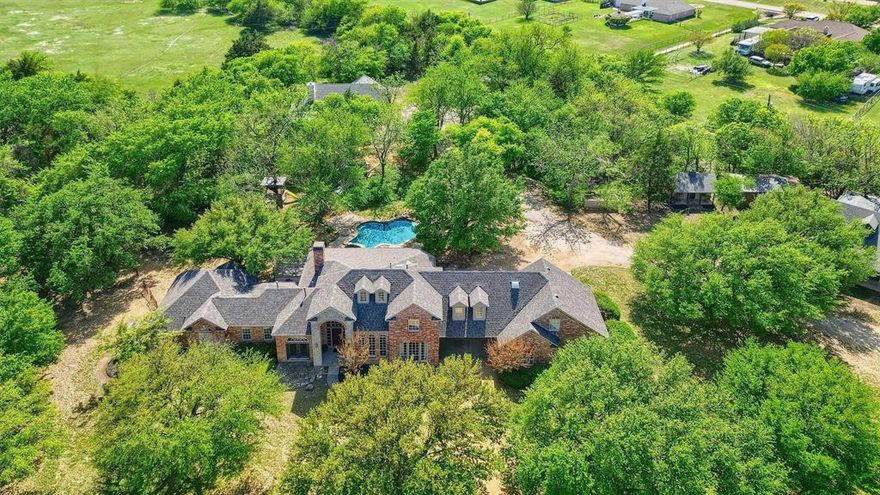 Welcome to your dream retreat at 8515 Country Creek Lane, nestled in the heart of Prosper, TX, where luxury meets versatility on a spacious 6.5-acre paradise. This sprawling estate offers not one, but two stunning homes, making it a rare find for those who value space and style.The main residence boasts 4 luxurious bedrooms and 3.5 pristine bathrooms across an impressive 3063 square feet. Step inside to discover high ceilings adorned with chandeliers and recessed lighting, complemented by elegant crown and decorative mouldings. The updated master suite is your personal haven, complete with a custom walk-in closet and a versatile flex room perfect for exercise, office work, or a nursery.  Entertain in style with panoramic views and a private pool that promises endless summer fun. The second home, built in 2021, features 2 bedrooms and an open floorplan with high ceilings, gorgeous beams, and a captivating stone fireplace. An additional outbuilding with full utilities offers endless possibilities—a man cave, office, or another living space.With an oversized garage ready for your boat or truck and an AG exemption, this property is not just a home; it's an adventure waiting to happen!