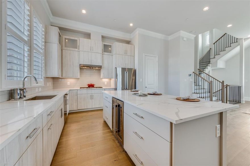 This stunning residence is currently the largest available townhome at Cedar Branch, ideally positioned just minutes from Oak Lawn, Uptown, and the Medical District—placing Dallas’ premier dining, shopping, and entertainment within effortless reach. Crafted by InTown Homes, this exceptional four-level residence offers elegant, refined living with three bedrooms, three and a half baths, and thoughtfully designed spaces that balance sophisticated entertaining with everyday comfort.
  A dramatic open staircase spanning all four levels serves as a striking architectural centerpiece, enhancing the home’s contemporary design. The main living level impresses with 12-foot ceilings, rich crown molding, and a 10-foot sliding glass panel door that opens to a private balcony, seamlessly blending indoor and outdoor living. The gourmet chef’s kitchen is beautifully appointed with a Bosch stainless steel appliance package, exquisite quartz countertops, designer tile backsplash, and stacked upper cabinetry that deliver both style and function.
  The luxurious primary suite offers a serene, spa-inspired retreat, complete with a freestanding soaking tub, oversized walk-in shower, and an expansive walk-in closet designed for effortless organization. Premium engineered hardwood flooring flows throughout the home, adding warmth and sophistication across every level.
  At the top, a private rooftop terrace creates an inviting setting for outdoor entertaining, sunset gatherings, or relaxing evenings while enjoying sweeping views. Blending modern architecture, upscale finishes, and a prime location, this exceptional residence delivers a lifestyle defined by luxury, thoughtful design, and effortless urban living in one of Dallas’ most desirable locations.