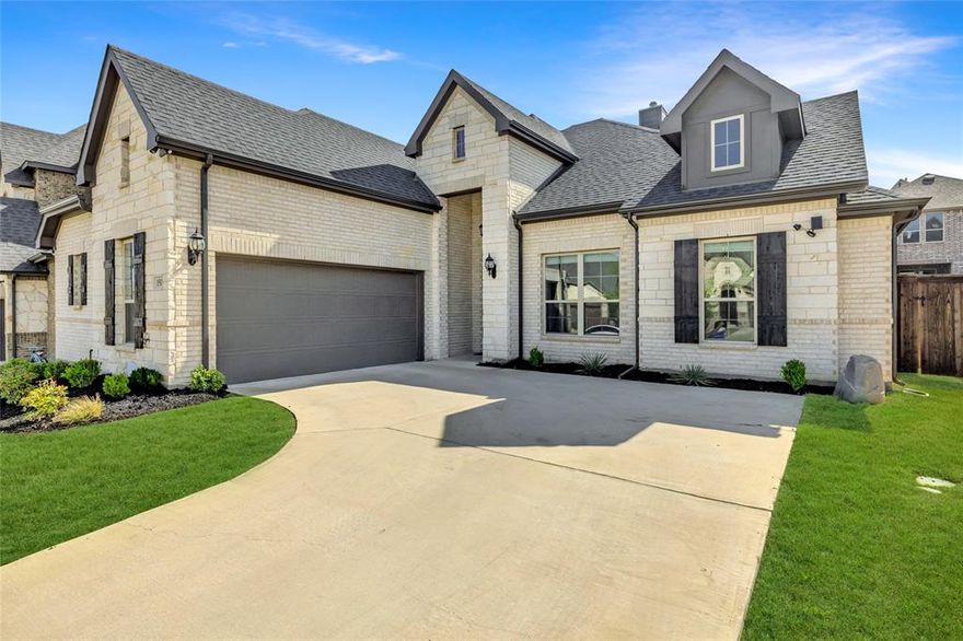 Don’t miss this exceptional 4-bedroom, 3-bathroom home in the prestigious M3 Ranch community one of Mansfield’s most sought-after neighborhoods. Located within the acclaimed Mansfield ISD, this beautifully designed property offers a rare combination of luxury, comfort, and functionality. From the moment you arrive, you’ll appreciate the attractive curb appeal enhanced by a stylish J-swing garage, which not only adds character but also provides additional parking space. Step inside to discover a thoughtfully designed open-concept layout that seamlessly connects the kitchen, dining, and living areas perfect for both entertaining and everyday living. The kitchen is a true showpiece, featuring sleek stainless steel appliances, elegant quartz countertops, a walk-in pantry, and a stunning herringbone tile backsplash. The living room is warm and inviting, highlighted by wide plank hardwood flooring, a modern fireplace, and soft neutral color tones throughout. The spacious primary suite serves as a relaxing retreat, complete with room for a sitting area and a luxurious en-suite bath featuring dual vanities, a garden tub, a separate walk-in shower, and a large walk-in closet. One of the secondary bedrooms and a full bathroom are privately located in a separate wing of the home ideal for use as a guest suite, multigenerational living, or a dedicated home office. Step outside to enjoy a beautifully landscaped backyard with a covered patio perfect for relaxing evenings, weekend gatherings, or enjoying a quiet morning coffee. Additional upgrades and features include energy-efficient windows, high ceilings, 8ft doors, modern lighting fixtures, and abundant storage throughout. Special Financing Incentive: Up to 5% Toward Buyer’s Closing Costs with Preferred Lender! This home combines quality craftsmanship, designer finishes, and an unbeatable location in M3 Ranch schedule your private tour today!