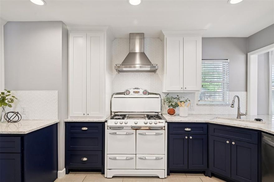 That navy kitchen with the 1953 O'Keefe & Merritt is the reason you'll schedule a showing. The rest of the house is why you'll write an offer.

A Dilbeck-inspired mid-century ranch on a corner lot in Stevens Park Village — one of Oak Cliff's best-kept secrets. Just 141 homes, built primarily between 1939 and 1942, on tree-lined streets where the neighborhood association still hosts wine walks and holiday gatherings. Named one of the Dallas Morning News' top 10 neighborhoods.

The covered front porch pulls you in before the door opens. Striated Roman brick, vintage brass hardware, a bold blue door — the kind of details that tell you someone has always cared about this house. Inside, original hardwood floors stretch through every room. A textured Austin stone fireplace anchors the living room, flanked by walls of windows that fill the space with afternoon light. The flow between living and dining feels effortless — open enough for a dinner party, intimate enough for a Tuesday night.

Then there's that kitchen. Navy cabinetry, quartzite countertops, and glass-front uppers with cathedral detail. The restored 1953 O'Keefe & Merritt — four gas burners, a Grillevator broiler, Vanishing Shelf, and an oven that cooked every single day — is the kind of piece collectors hunt for. This one stays with the house.

A peninsula with bar seating opens to the den — beadboard ceiling, soft gray-blue walls, the room you didn't know you needed until you're reading in it on a Saturday morning. Generous bedrooms throughout, and both baths are fully updated, including a spacious walk-in shower off the primary.

Out back, a full deck under mature shade trees and a fenced yard that feels like its own world. Attached 2-car garage. Minutes from Bishop Arts, Sylvan Thirty, and Trinity Groves.