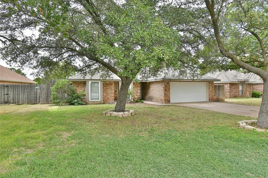 Move-in ready with thoughtful updates, this 3-bedroom, 2-bath home in Heritage Parks is a true gem. A split floor plan and vaulted ceilings create an open, functional layout, while a cozy wood-burning fireplace adds warmth to the spacious living room. The kitchen features granite countertops, a center island, and plenty of space for meal prep or entertaining.  The primary suite offers a modern en-suite bath with a stylish soaking tub-shower combo, dual walk-in closets, and updated tile work. Fresh paint and new carpet make this home feel new.  Step outside to enjoy the mature shade trees, covered back porch, and dog run—perfect for pets or a garden. In addition to a small storage building, the property includes a larger electric-equipped metal workshop, offering endless possibilities for hobbies, storage, projects, or a home business.  Conveniently located near ACU, HSU, Hendrick Medical Center, shopping, and dining, this property combines comfort, function, and location in one complete, affordable package.