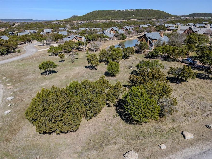 Build your lake retreat on this expansive .66-acre corner homesite in the exclusive, guard-gated community of The Harbor at Possum Kingdom Lake. Located within one of PK’s most prestigious and amenity-rich neighborhoods, this property offers the opportunity to enjoy a private, resort-style lifestyle defined by security, elegance, and community. Residents enjoy an exceptional collection of upscale amenities including a beautiful community pool with multiple hot tubs, a full-service spa and state-of-the-art fitness center, an impressive sports complex, stocked fishing ponds, scenic walking trails, and playground areas. The Patterson Marina and Hemingway's are just a short golf cart ride away, making boating days and waterfront dining effortlessly accessible. With established architectural guidelines that maintain the integrity and sophistication of the neighborhood, this premier corner homesite offers the ideal setting for those seeking exclusivity, luxury, and the best of Possum Kingdom Lake living.