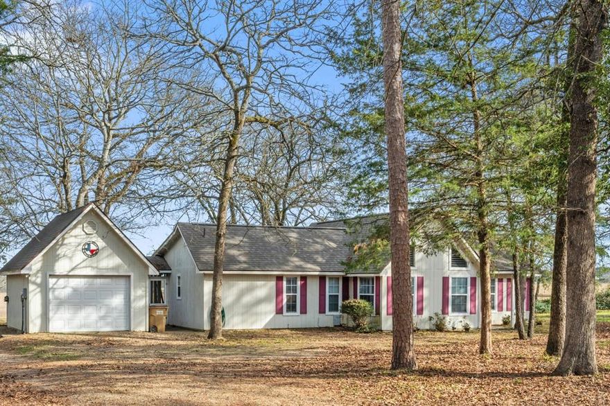 Tucked away on a beautifully wooded lot in the heart of East Texas, this inviting 2-bedroom, 2-bath home offers an ideal blend of privacy, comfort, and scenic beauty—perfect for escaping the pace of city life. Located approximately 100 miles west of the Dallas–Fort Worth Metroplex, the property features a one-car garage and a tranquil setting where mature trees surround the home, while open views provide stunning sunset vistas to enjoy each evening. Inside, vaulted ceilings enhance the sense of space and natural light, creating a warm and airy atmosphere throughout the living areas. The home also boasts a generously sized kitchen, perfectly suited for entertaining family and friends during the holiday season and beyond. A screened in breezeway attaches the house to the garage. Situated within the highly sought-after Holly Lake Ranch, a 24-7 gated community, residents enjoy access to an exceptional array of amenities, including tennis and pickleball courts, fishing, scenic hiking trails, an 18-hole golf course with driving range, a fitness center, and a dedicated dog park. The community also offers a wide variety of social organizations and clubs, making it easy to build lasting friendships and enjoy an active, connected lifestyle. Whether used as a full-time residence or a weekend retreat, this property provides a peaceful retreat from urban living while offering resort-style amenities in a secure, well-established East Texas community.