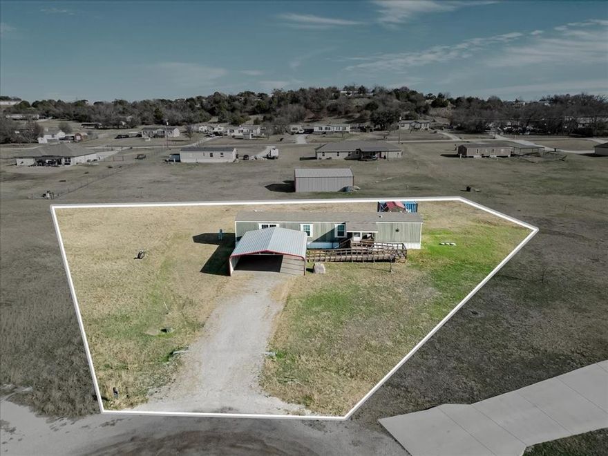 Welcome to your peaceful retreat, this charming 3-bedroom, 2-bathroom single-wide mobile home offers the perfect blend of country living and modern convenience. Situated on a quiet just over an acre cul-de-sac lot in Parker County, you’ll enjoy the benefits of no city taxes and no HOA fees.
Conveniently located between Weatherford and Springtown. This home is packed with value! The refrigerator, washer, dryer, and water softener all convey with the property. For those who love projects or need extra space, the property features a workshop with electricity and a  additional storage container. Your peace of mind is also prioritized with an included security system complete with cameras and alarm. If needed, I can put you in contact with a lender for single wide mobile homes.
This property is located in the Weatherford ISD, and provides a fantastic opportunity for homeowners looking for space and flexibility. Start your day right and enjoy your morning coffee while taking in the serene view of this one acre lot.