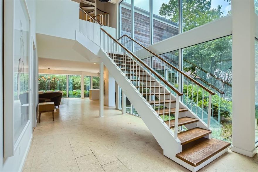 Located in a quiet cul-de-sac just minutes from I-635 and Forest Ln, this striking 3-bedroom, 2.5-bath contemporary home blends bold architecture with inviting comfort. The dramatic foyer features soaring windows and exposed beam stairs, setting the tone for a home filled with style and natural light. With windows galore, the entire home feels open and bright from every angle. At the front, a sitting room offers a peaceful retreat, while additional spaces include an office, den, and a spacious living room with a fireplace that seamlessly connects to the dining area and eat-in kitchen. A sleek, contemporary half bath with a neutral palette adds a refined touch to the main level. Upstairs, all three bedrooms are thoughtfully arranged, including a stunning primary suite with a brick-faced fireplace, large walk-in closet, built-in wet bar, dual vanity, soaking tub, glass-framed shower, and a private balcony overlooking the backyard pool. A circular staircase leads to a unique loft space—ideal for a creative nook, study, or lounge. The fenced backyard is a true escape, featuring an in-ground pool and lush, private surroundings that create a peaceful visual paradise. The home also featues a Crestron AV system throughout. The light fixtures are premium and designed by an award-winning lighting designer. 9 rooms of audio plus exterior speakers. Discounted rate options and no lender fee future refinancing may be available for qualified buyers of this home.