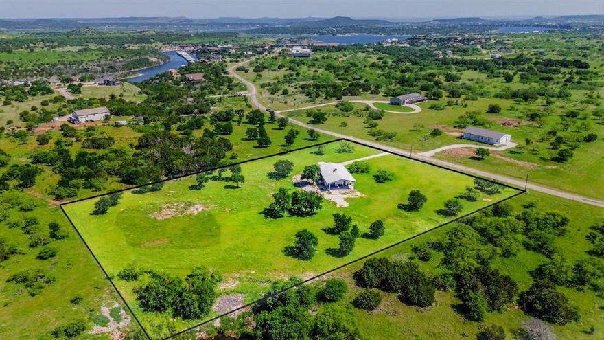 OWN LA GRANGE! Don't miss the opportunity to own the ultimate Man-Cave in Sportsman's World! An icon in Sportsman's World, La Grange is a fully fenced private 5-acre ranch with an electric gate for security. Designed with functionality in mind, the property includes two large bays measuring 12 x 12 and 12 x 16, ideal for storing your boat, side-by-side, or other lake toys. Features an additional 30-amp RV Hookup and septic hookup for immediate extra space. This property blends Texas countryside charm with modern comfort, creating the perfect escape for lake lovers and outdoor enthusiasts alike. The impressive 40 x 80 metal building has been thoughtfully transformed into a stylish, climate-controlled living space where rustic meets refined. Inside, you’ll find a well-appointed kitchen featuring granite countertops and modern appliances, along with comfortable living quarters filled with natural light and warm, inviting finishes. The loft offers a king-size bed and a queen futon, providing plenty of space to relax and unwind. A 28-foot storage container adds even more room for equipment and gear. Step outside and enjoy the expansive outdoor setup, complete with a 20 x 40 patio featuring a fire pit, bar area, and Weber grill, perfect for entertaining after a long day on the lake. With ample space for parking, trailers, and additional equipment, this property offers both freedom and flexibility. Whether you're looking for a weekend getaway, a full-time retreat, a party barn or overflow. This is lake life done right.