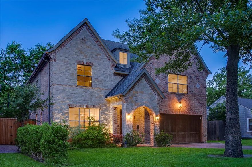 Some homes feel immediate. Not because they demand attention, but because they make you feel at ease the second you arrive. Framed by mature trees and soft evening light in M-Street Area, this home balances timeless architecture with interiors that feel grounded, calm, and genuinely welcoming. Rich hardwood floors run throughout, contrasted by soft neutral walls, detailed millwork, and expansive windows that frame greenery from nearly every angle. The main living spaces feel connected without losing definition, with a generous living room anchored by a fireplace that opens naturally into the breakfast area and kitchen, where custom cabinetry, stone surfaces, and warm lighting create a space that feels inviting and functional all at once. Morning light filters gently through the breakfast nook, while the covered patio beyond extends daily life outdoors beneath the trees. A dedicated office near the entry offers separation for work or creative focus, tucked just enough away from the home’s central rhythm. Upstairs, the bedrooms feel unusually expansive, including a serene primary suite with tray ceilings, layered lighting, dual vanities, soaking tub, and natural stone finishes that create a quieter sense of retreat. An oversized flex space adds versatility for media, wellness, or evolving lifestyle needs. Outside, the backyard feels remarkably private for this part of Dallas, surrounded by mature landscaping, turfed yard for optimal green year round, and a covered lounge designed for slower evenings and relaxed weekends at home. Positioned just minutes from Greenville’s restaurants, cafés, and neighborhood energy, with quick access to White Rock Lake’s trails and outdoor lifestyle, the location balances connection and calm with ease. The Dallas Arboretum nearby adds another layer to the experience, especially during spring and fall when East Dallas feels at its best. A home that feels grounded, thoughtful, and deeply livable from the moment you walk in
