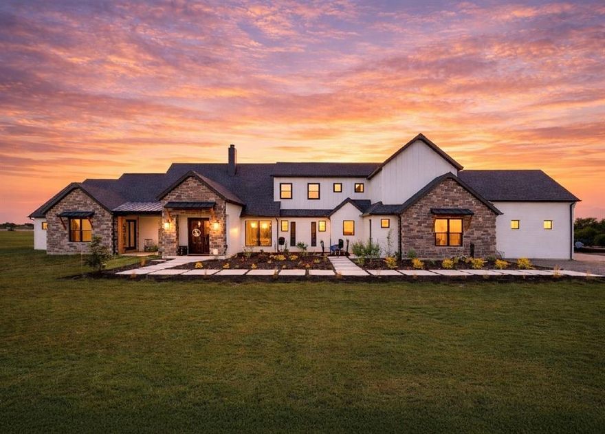 Sitting at the edge of Collin and Grayson County, this Contemporary Texas Modern Farmhouse rests on approximately 3.25 acres within a 2000+ acre Red Stag Ranch that has an enclave of larger acreage properties. When you drive the last 3 miles you will feel you are in the Texas Hill Country. Intentionally situated away from the pace of city life, the homestead offers open land, wide skies, and the kind of quiet only found where space and sky outnumber rooftops.

Approaching the homestead, open acreage gives way to a walking path framed by black obsidian aggregate that leads to handcrafted Entrada 8' double iron front doors, creating a calm and intentional arrival.

Inside, the heart of the home centers around a floor to ceiling wood burning fireplace constructed of Silvermist chopped stone with custom live edge cedar mantels. The open living spaces are complemented by custom lighting crafted from reclaimed materials, including wagon wheels sourced from McKinney & Canton Trade Days.

The chef’s kitchen features Shadow Storm Brazilian marble countertops, including a single slab leathered island, honed perimeter counters, extensive storage, and a cabinet lined pantry designed to maintain a clean and organized space.

The private primary wing includes an office, coffee bar, laundry access, and a spa inspired bathroom with radiant heated floors, an oversized dual double Jacuzzi tub, and a dual access slate shower with rain head, body sprays, and multiple fixtures.

Additional features include a secondary suite with heated bathroom floors, walk in closets throughout, a soundproof media room, upstairs and downstairs laundry, spray foam insulation, a 20 zone sprinkler system, tankless water heater, finished attic flex space, and an 8 car garage with an extra tall bay suitable for RV or boat storage.

Blending handcrafted materials, reclaimed elements, and thoughtful design, this homestead offers a modern interpretation of the Texas farmhouse.