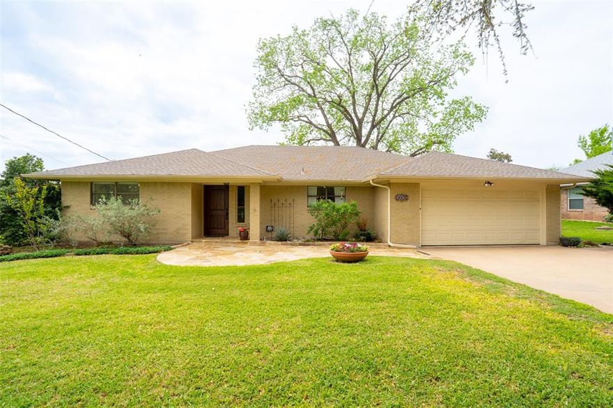 WATERFRONT DREAM HOME! Set on the peaceful shores of Lake Granbury, this beautifully maintained brick home blends comfort, style, and that easygoing lake lifestyle people move here for. Mornings start slower here-coffee on the back porch, watching the water and evenings naturally turn into gatherings with friends and family. Inside, the living room is warm and welcoming, centered around a wood-burning fireplace and open to the dining area so everyone stays connected. It’s the kind of space where holidays are celebrated and everyday moments feel a little more special. The primary suite is a true retreat-spacious, updated, and with direct access to the back porch so you can step outside anytime you want. The ensuite bath has been thoughtfully redone with quartz countertops, dual sinks, and a large frameless glass shower with multiple shower heads. The custom closet system keeps everything organized without sacrificing style. The kitchen has been refreshed with granite countertops, a farmhouse sink, KitchenAid convection wall oven, and upgraded lighting that makes the space feel both functional and inviting-whether you’re cooking for two or hosting a full house. Step outside and you’ll really understand what makes this home special. The backyard opens up to the lake, complete with a boat dock, cradle lift, and a separate jet ski dock so getting out on the water is always easy. There’s even a lake-fed irrigation system to keep the yard looking great year-round, plus extra storage with a Tuff Shed. And when you do decide to leave your lakeside retreat, you’re just minutes from the charm of the historic Granbury Square, along with great restaurants, shopping, schools, and medical facilities. This isn’t just a house, it’s where weekends feel longer, sunsets feel closer, and lake life becomes your everyday. Enjoy all of this yourself or you can use as a short-term rental!