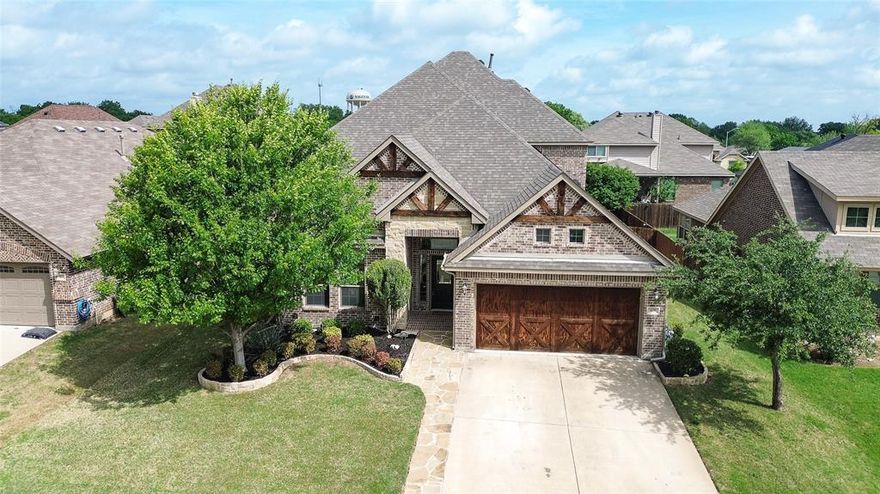 Tucked on a quiet cul-de-sac in Saginaw Springs, this 2015 Lillian Custom Home stands out with a striking brick & stone elevation, exposed timber accents, & custom barn-style garage doors. Inside, the bright, open kitchen features white cabinetry, brick backsplash, granite countertops, a large island, pendant lighting, & a true walk-in pantry, all flowing seamlessly into the main living area with a stone fireplace. A dedicated study at the front offers the perfect home office or flex space. The primary suite is downstairs with dual vanities, soaking tub, separate shower, & a spacious walk-in closet. Upstairs delivers exceptional flexibility with a massive second living area, 3 additional bedrooms, & a private en-suite bath—ideal for guests, teens, or multi-generational living. The powder bath & upstairs bath add character with thoughtful finishes that set this home apart. The backyard is built for both relaxing & entertaining with a flagstone patio, custom pergola, stepping stone path, & mature landscaping. The tandem 3-car garage is currently configured as a 2-car with a separate air-conditioned storage room, but can easily be converted back to a full 3-car setup if desired. Offering over 3,000 SF, 4 bedrooms, & 3.5 baths in Eagle Mountain-Saginaw ISD, this home is well-positioned within one of the area’s most desirable neighborhoods.