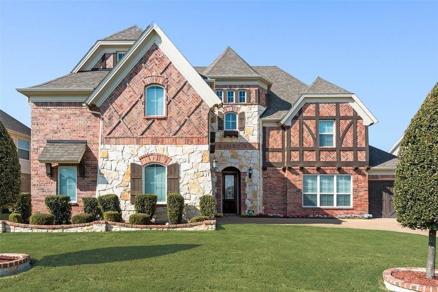 Bower Ranch beauty in Mansfield, TX! This elegant two-story spans 4,440 sq ft with 5 bedrooms and 4 full baths, perfectly designed for everyday living and memorable entertaining. Grand entry showcases a wrought-iron dual staircase and well-maintained hardwoods. Formal living and dining provide flexible gathering spaces, complemented by a dry bar under the stairs with generous storage. The oversized kitchen impresses with granite countertops, dual ovens, built-in microwave, 6-burner gas range, and a large walk-in pantry. Enjoy a cozy breakfast nook with window seating. Large main living room features a corner cast-stone fireplace and is overlooked by a dramatic second floor catwalk. First floor primary suite offers window seating, a jetted tub, large walk-in shower, dual sinks, and a spacious walk-in closet. A utility room with built-ins and a closet adds convenience. Upstairs delivers a dedicated media room, a large game room, and a second primary suite with en suite bath, ideal for multi-generational living. Outside, entertain on the covered patio with built-in grill. Highly sought after location with easy access to shopping, freeways, schools, and DFW Airport. Don’t miss this exceptional opportunity!