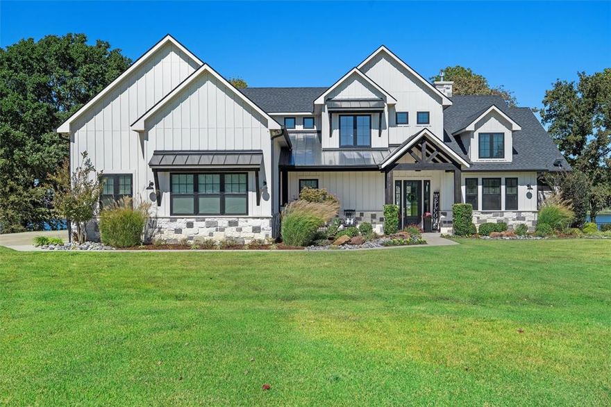 Welcome to your dream lakefront retreat in The Shores' premier gated community. This stunning property on over an acre boasts 177 feet of serene shoreline in a protected cove- perfect for watersports or a relaxing lake front view. Launch your boat from your dock in some of the deepest water in the cove. Shade trees & a fire pit await chilly nights or stargazing. The large, covered patio with motorized screens, built in gas grill, granite counters, & fridge shines for outdoor entertaining and enjoying the lake breeze. The beautiful, maintained grounds include a lake fed sprinkler system. Inside, you will find luxury living with a well-appointed kitchen featuring Bosch appliances, quartz counters, gas cooktop, double ovens and microwave.  A large island with bar seating handles dining and guests. The open concept kitchen blends seamlessly with the dining and living areas. Sliding windows in the living room frame breathtaking views and open to the patio for an additional entertaining space. Designed for entertaining, the home includes a billiards room with reclaimed wood recess ceiling, full wet bar, fridge and striking backsplash. The oversized primary suite is a private retreat with a beautiful lake view; vaulted wood beamed ceiling and French doors for patio access. The spa-like bath features designer tile, a large double headed shower, handheld shower wand, oversized soaking tub, dual vanities, and his & her walk in closets. Hers is a large dream closet with a custom closet concept and chandelier! His closet has direct access to a large laundry room with a designer dog wash!  Upstairs, a bedroom wing hosts family & friends-each room unique, plus, a bunk room with 4 full-size built-in bunkbeds and its own private living area- ideal as a bonus room. As furnished today, the home can sleep 12 - 16 people. The oversized 3 car garage includes a workshop. Whole house water filtration & insect misting systems. Just 1 hour 15 minutes from Dallas - create lake life memories!