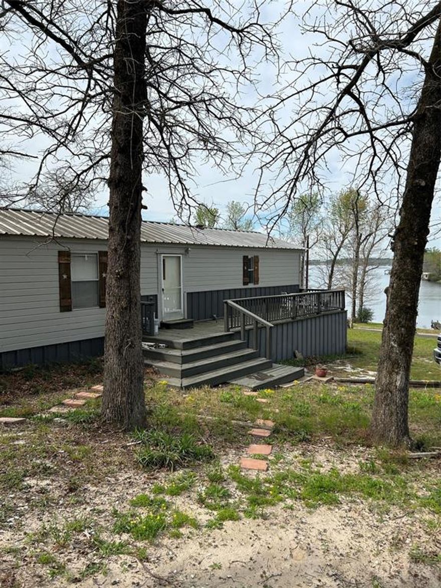 WOW! What an AMAZING NEW PRICE for a WATERFRONT ON LAKE HAWKINS! Super Clean! Not many lakefront properties available on popular spring fed Lake Hawkins, especially at this price. Turn Key and Ready for you to move on in and start enjoying beautiful Lake Hawkins. Freshly Painted 3 bedrooms, 2 bathrooms, large living with fireplace which opens to eat in kitchen, all appliances included, including washer and dryer New vinyl flooring in master, kitchen, and utility room. AC unit has a warranty and the duct work has been cleaned. The master bedroom is a good size and has a freshly refinished garden tub bath with a separate shower. Secondary bedrooms are on the other end and share a bath with tub shower. Large wooden deck in front with great lake views. There is a dock but it does need attention. Exterior has been freshly painted as well and new shutters placed. This property has much potential for several options such as Air B&B, Rental, Weekend Home, Second Home or simply your Main Home! Great opportunity to have a lake front property at a reasonable price! Make your appointment today! Contact Agent Now! Lake Hawkins is a spring fed lake and 600 plus acres in size. Super Nice Lake!