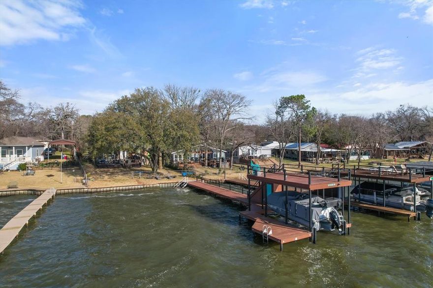 Discover your dream lakefront oasis at Cedar Creek Lake! This stunning waterfront home is an entertainer's paradise, featuring a spacious covered porches and sitting deck, and detached full apartment for extra living space! This lake home is perfect for hosting friends and family. Fully fenced lot offers a worry-free environment for kids and pets, while the inviting outdoor space is ideal for cozy evenings under the stars. The new two level boat house has watercraft lift, swim deck and level 2 open deck. Positioned on wide, deep water with an endless view! Inside you will find a home that is just as perfect as the outdoor, open water views! Walk in to enjoy an open-concept living space, new kitchen with a spectacular view and custom island bar area, primary suite with ensuite bath, convenient half bath and full-size laundry.  Level 2 is so much fun! 690 square foot, massive game room with pool table, TV area, wet bar and level 2 balcony. Upstairs you will also find two additional bedrooms and another full bath. The bonus apartment above the garage offers additional space for guests with its own private living area, kitchen, full bath and bedroom. One car garage has workbench and ample storage.  With all the space this property offers you can host all you friends and family. Don’t miss out on this incredible opportunity!