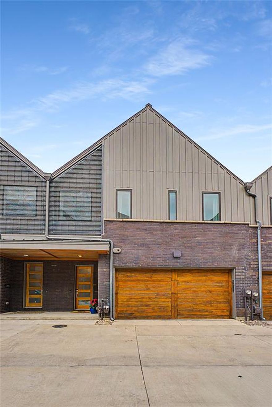 Experience the ultimate lock and leave lifestyle in this impeccably upgraded home located at the quiet rear of a premier gated community. Built in 2021 and enhanced with over two years of high end custom finishes, this residence offers a homey, spacious feel that belies its convenient urban location. The property uniquely backs to a lush green space that is a private one-acre fenced park for resident use, allowing you to enjoy tranquil views and direct park access without the burden of maintenance. The interior showcases extraordinary craftsmanship, starting with custom built in oak cabinetry in the living room and designer lighting throughout the kitchen and dining areas. Entertaining is effortless with a bespoke dining room bar featuring an integrated wine fridge and professional grade wallpaper. The upstairs loft serves as a perfect home office with a custom built in desk and matching cabinetry. Every detail has been considered, including stylish wallcoverings in the powder and primary baths. Step outside to a private oasis featuring a professional paver patio and premium artificial turf for year round, low maintenance beauty. The gourmet outdoor kitchen is a chef's dream, equipped with a modular six burner grill, side searing station, and ample storage. The garage has also been transformed with high quality epoxy flooring, custom cabinetry, and heavy duty ceiling racks for maximum organization. Centrally located with a straight shot to Love Field, DFW Airport, and all major highways, this home is perfectly positioned for those who love to travel the world but want a luxurious sanctuary to return to. Enjoy the peace of mind that comes with a gated community while reaping the rewards of a property that feels much larger thanks to its seamless connection to the natural parkland behind it.