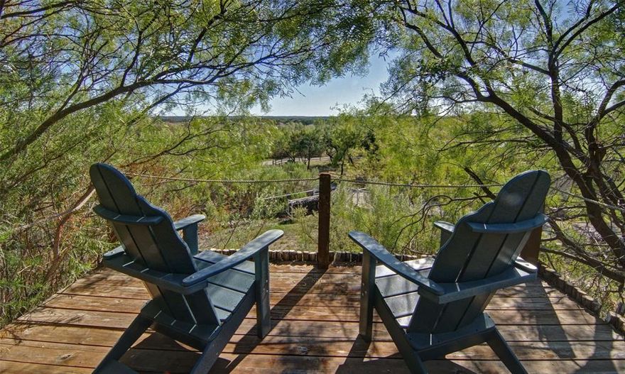 Introducing a remarkable opportunity to acquire a genuine slice of Texas history dating back to the year 1915. This iconic residence built by John Kennedy Weldon, is nestled within the esteemed confines of The gated Ranch community, resting upon just over 2.5 acres completely devoid of any intrusive HOA assessments. Embraced by serene ambiance provided by the surrounding trees, this historic 2 bedroom cabin underwent a tasteful renovation in 2005, ensuring the retention of original walls and floors, thus seamlessly blending modern amenities with the timeless allure of rustic charm. Savor the gentle caress of the breeze from the comfort of the covered porches, or indulge in moments of tranquility beside the picturesque pond, complete with a delightful dock. Accommodating guests is made effortless with the presence of an additional bunkhouse, while the expansive barn garage effortlessly accommodates all of your cherished lake toys. Please contact agent for additional historical info