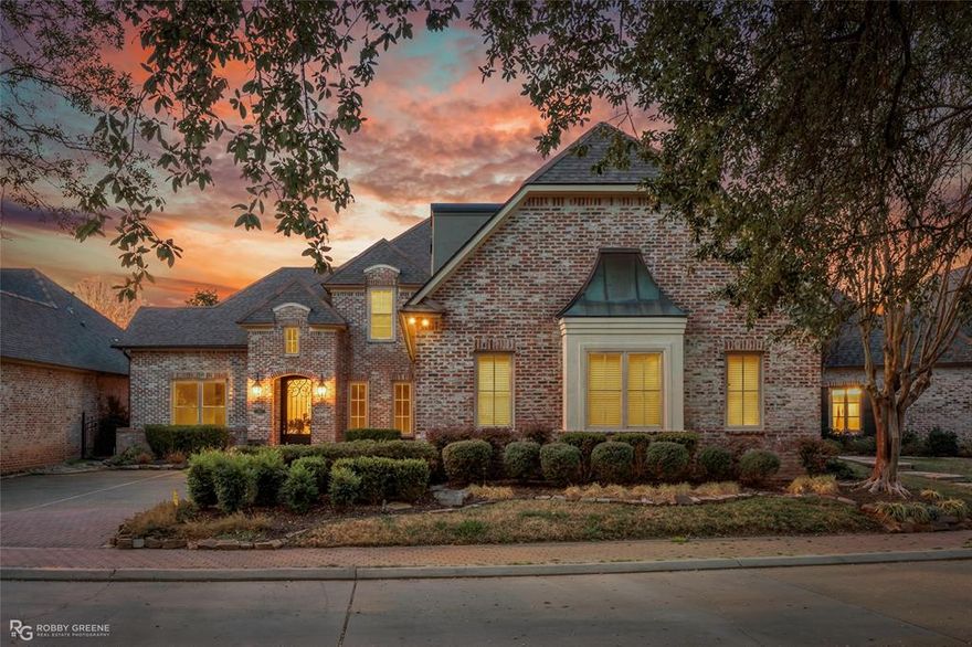 Nestled behind the gates of Oak Alley, one of North Bossier’s most coveted neighborhoods, this exceptional luxury residence offers over 4,000 square feet of refined living designed for both grand entertaining and everyday comfort. Featuring five bedrooms and three-and-a-half baths, the thoughtfully designed floor plan includes a luxurious primary suite on the main level with a spa-inspired bath showcasing a soaking tub, gas fireplace, expansive walk-in shower, dual vanities with lighted mirrors, and a custom-built closet. The chef’s kitchen is a true showpiece with a gas Jenn-Air range, double ovens, large pantry, farmhouse sink, ice maker, and seamless flow into the main living area, where custom built-ins and a striking two-way fireplace create warmth and sophistication. Walls of windows overlook a private backyard retreat complete with an inground pool, expansive decking, covered patio, outdoor kitchen and grill, firepit, water feature, lush landscaping, irrigation system, and mosquito misting system—an entertainer’s dream. Upstairs offers four additional bedrooms, two full baths, two versatile flex spaces ideal for a media room, office, or playroom, along with a dedicated upstairs utility room, while a second utility room on the main level adds everyday ease. Additional highlights include a three-car garage with insulated doors, formal living and dining rooms, breakfast area, wet bar, hardwood flooring, updated flooring throughout, multiple newer HVAC systems, solar attic vents, security system, and extensive updates that reflect pride of ownership and thoughtful investment. This home delivers timeless elegance, exceptional function, and resort-style living in a premier gated setting.