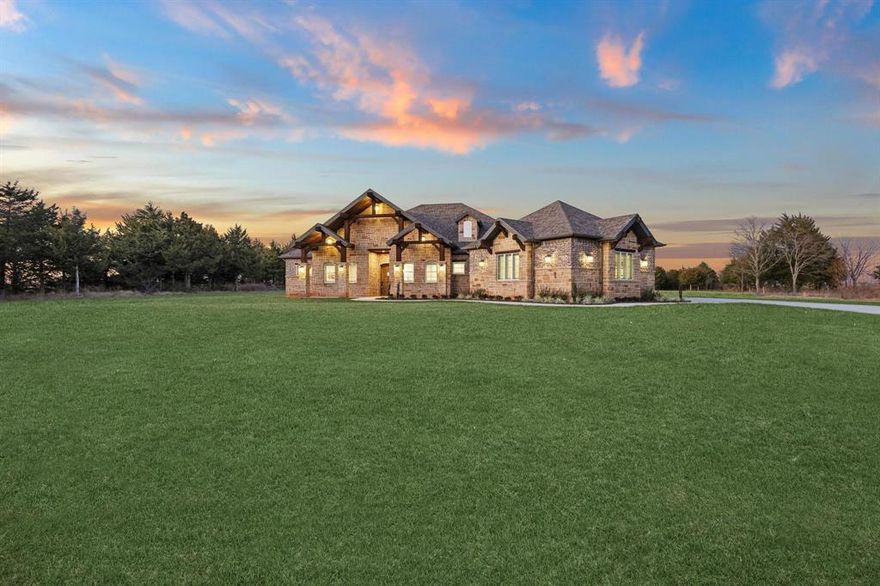 Nearly new custom home built in 2022 offering exceptional design, privacy, and resort-style outdoor living, with attention to detail and craftsmanship throughout. This all-brick residence features 4 bedrooms and 4 full bathrooms, including a thoughtfully designed primary suite with two separate private toilet rooms, individual vanity areas, and a spacious walk-through closet with access from both sides of the ensuite bath.

The home offers two side-entry garages—one single-car and one two-car. A thick line of mature trees provides privacy from the street, opening to a large front yard and welcoming brick façade.

Inside, the open-concept kitchen, dining, and living area is ideal for everyday living and entertaining, anchored by a dramatic floor-to-ceiling stone fireplace. Stained wood ceiling accents in the living room and primary bedroom add warmth and architectural character.

The kitchen showcases custom stained cabinetry throughout, custom brick accents sourced from a specialty supplier in Chicago, and generous countertop space. A wrap-around island with elevated bar seating for six creates a natural gathering space, while a separate center island houses the 5-burner gas cooktop. Matching modern appliances include a refrigerator, double wall ovens, undercounter wine chiller, undercounter ice maker, microwave drawer, and undercounter trash compactor.

The home includes hardwood flooring in main living areas, custom tile in bathrooms, and new carpet in bedrooms, along with built-in speakers and smart wiring centralized in a media closet off the parlor, flex room.

French doors lead to an outdoor living area with a floor-to-ceiling stone fireplace and stained wood ceiling, overlooking a custom freeform pool featuring a grotto with waterfall, slide, and fire bowls, surrounded by stamped and stained concrete decking.

Additional acreage available, including approximately 2 acres of irrigated sports field area and 5 treed acres.