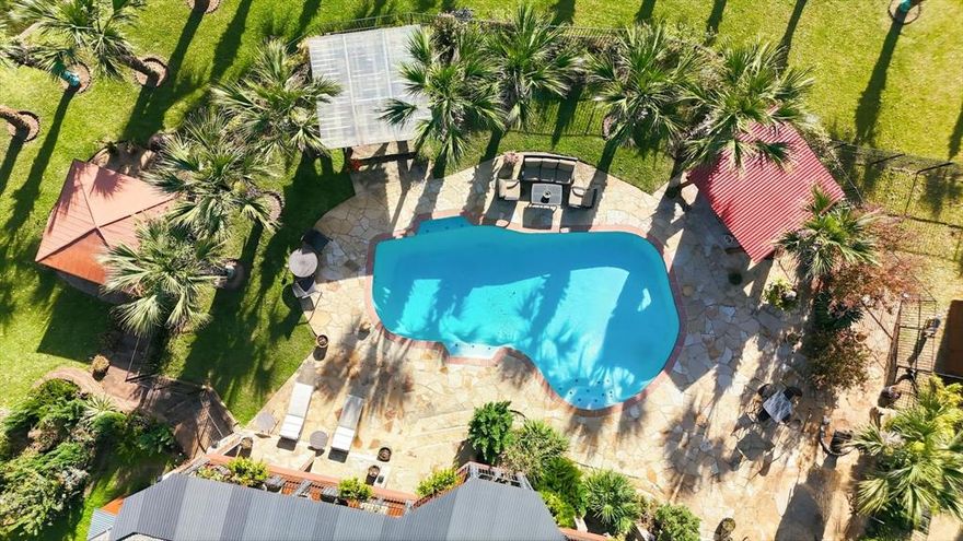Rare, one-of-a-kind, resort-style lakefront retreat in the heart of the DFW Metroplex, tucked away on a quiet cul-de-sac and set on a beautifully landscaped .34-acre lot with direct frontage on a private lake and framed by 32 mature palm trees that create a serene, tropical atmosphere and everyday vacation vibes just minutes from town. Lush landscaping is irrigated directly from the lake, allowing you to enjoy stunning grounds without high water bills. Impressive open, light-filled living spaces designed for both everyday comfort and exceptional entertaining, including a grand living room and game room with panoramic lake views, custom wet bar, new wine fridge. The kitchen flows seamlessly into the den and formal dining area, making hosting family gatherings, dinner parties, and holidays effortless. The oversized primary suite serves as a private sanctuary with a spa-inspired bath and direct backyard access, perfect for enjoying peaceful mornings overlooking the pool, palms, and shimmering water. Step outside to your private oasis featuring a sparkling resort-style pool, flagstone decking and covered porch, expansive deck, private sauna with lighting and music, two powered gazebos, custom outdoor lighting, and breathtaking sunset views. This home offers peace of mind with a new Lennox HVAC system and condenser with 10 yr warranty, new roof, two 200-amp electrical panels, updated plumbing from meter to home, remodeled kitchen and downstairs areas, rod iron fencing, new front courtyard, 2 storage sheds including a greenhouse-style structure, 32 outdoor electrical outlets throughout yard & lakefront, custom outdoor lighting, and a 12-camera outdoor security system. An oversized three-car garage with a heated and air-conditioned half bath. More than a home, it's a lakefront lifestyle offering luxury, privacy, and comfort, where every day feels like a retreat and opportunities like this rarely come to market.