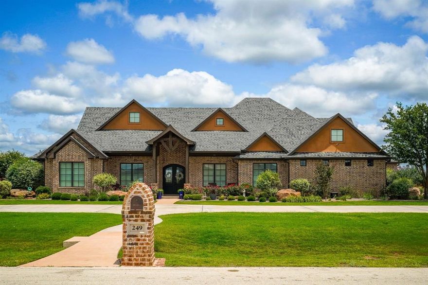 Exquisite luxury home on 1 acre with resort style amenities! Discover an extraordinary blend of elegance, comfort, and functionality in this stunning residence set on a beautifully landscaped 1-acre lot. A grand circle driveway welcomes you home, leading to an inviting entryway with immediate views of the breathtaking outdoor living retreat. Inside, the spacious living room features a striking fireplace with built-ins, seamlessly connecting to the formal dining room and a light-filled kitchen. The gourmet kitchen is designed for both beauty & performance, offering double ovens, a pot filler, custom cabinet drawers, a dedicated water filtration system, an ice maker, & a bar area with additional custom storage. The breakfast area is wrapped in natural light, creating the perfect spot to start your day. This home also includes a private office & a dedicated workout room with activity flooring. The secluded primary suite is a true sanctuary, highlighted by a brick focal wall, cozy fireplace, a spa inspired bathroom featuring a jacuzzi tub, walk-through tile shower, double sinks, & an expansive custom closet with built-in cabinetry & exceptional storage. Four additional bedrooms, 2 jack-n-jill bathrooms & a half bath provide ample space for family and visitors. Step outside to your own resort-style oasis. The expansive covered patio overlooks an incredible outdoor living space complete with a full outdoor kitchen, sink, refrigerator, & built-in cabinetry housing 2 TVs, plus a convenient outdoor bathroom complete with a shower. Enjoy year-round relaxation in the heated, self-cleaning saltwater pool, hot tub, fire bowls, & low-voltage landscape lighting. The property also features a playground, greenhouse, 500-gallon propane tank, & a whole-home Generac generator ensuring uninterrupted comfort.  This exceptional property offers luxury living at its finest, combining thoughtful design, high-end finishes, & unmatched outdoor amenities for an elevated lifestyle.