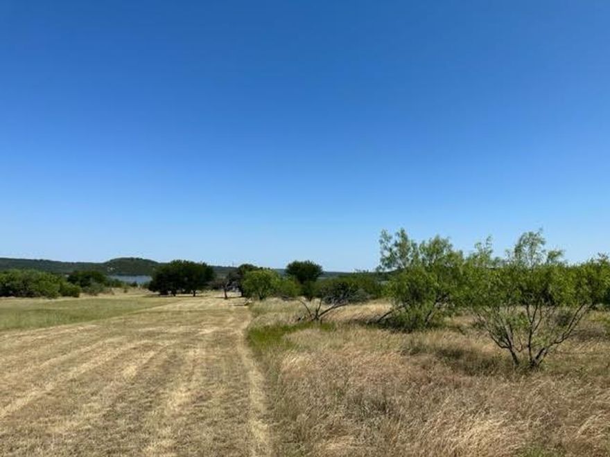 This one acre lot is on Possum Kingdom Lake, next to the BRA buffer zone. Lot is level with exceptional views of the lake and the surrounding hills. Lot ownership permits the use of all of the neighborhood amenities including the boat storage, boat ramp, community dock, picnic area and cabin, clubhouse with pool and fitness center, fishing pond, lake access, and twenty miles of private roadway behind the gates.