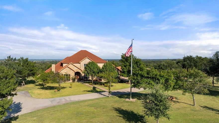 Stunning Custom home now offered in Stephenville Texas. Only 6 miles on the north side of town, You will fall in love with with the presence of this 10 acre Ranchette. Showcasing a copper roof, gorgeous landscaping, all the rock work and the front fencing of square tubing with rock columns and automatic entryway you're sure to appreciate the quality. Upon entering the 2 Story home the design flows easily adding custom knotty alder cabinets, inviting master bedroom with fireplace, and ensuite bedroom-baths upstairs. Plenty of space for family and friends and to entertain. This property offers a huge 4800 sq ft shop with LQ area plus a separate bunkhouse. Run a few head of livestock this land offers mature trees throughout,  a nice size pond and good sandy soil. Excellent location and high desirable area in Erath County.