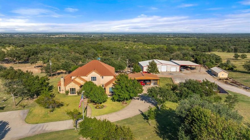 Stunning Custom home now offered in Stephenville Texas.  Multi-generational and only 6 miles from downtown!  You will fall in love with with the presence of this 10 acre Ranchette. Showcasing a copper roof, gorgeous landscaping, all the rock work and the front fencing of square tubing with rock columns and automatic entryway you're sure to appreciate the quality. Upon entering the 2 Story home the design flows easily adding custom knotty alder cabinets, inviting master bedroom with fireplace, and ensuite bedroom-baths upstairs. Plenty of space for family and friends and to entertain. This property offers a big functional 4800 sq ft shop with living quarters inside plus a separate bunkhouse. Ideal for 4-H projects or a few horses. This land offers mature trees throughout,  excellent fencing, a pond and good sandy soil. Great location in a high desirable area of Erath County.